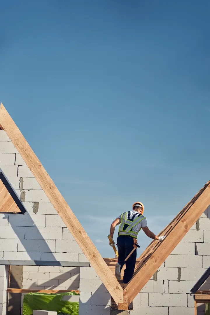 travailleur-des-hauteurs-entierement-adapte-debout-entre-les-toits-des-maisons-en-briques